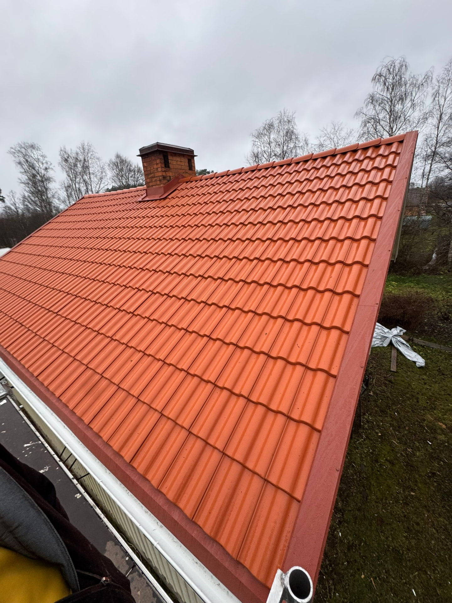 Nytt rött plåttak med vindskivor och hängränna