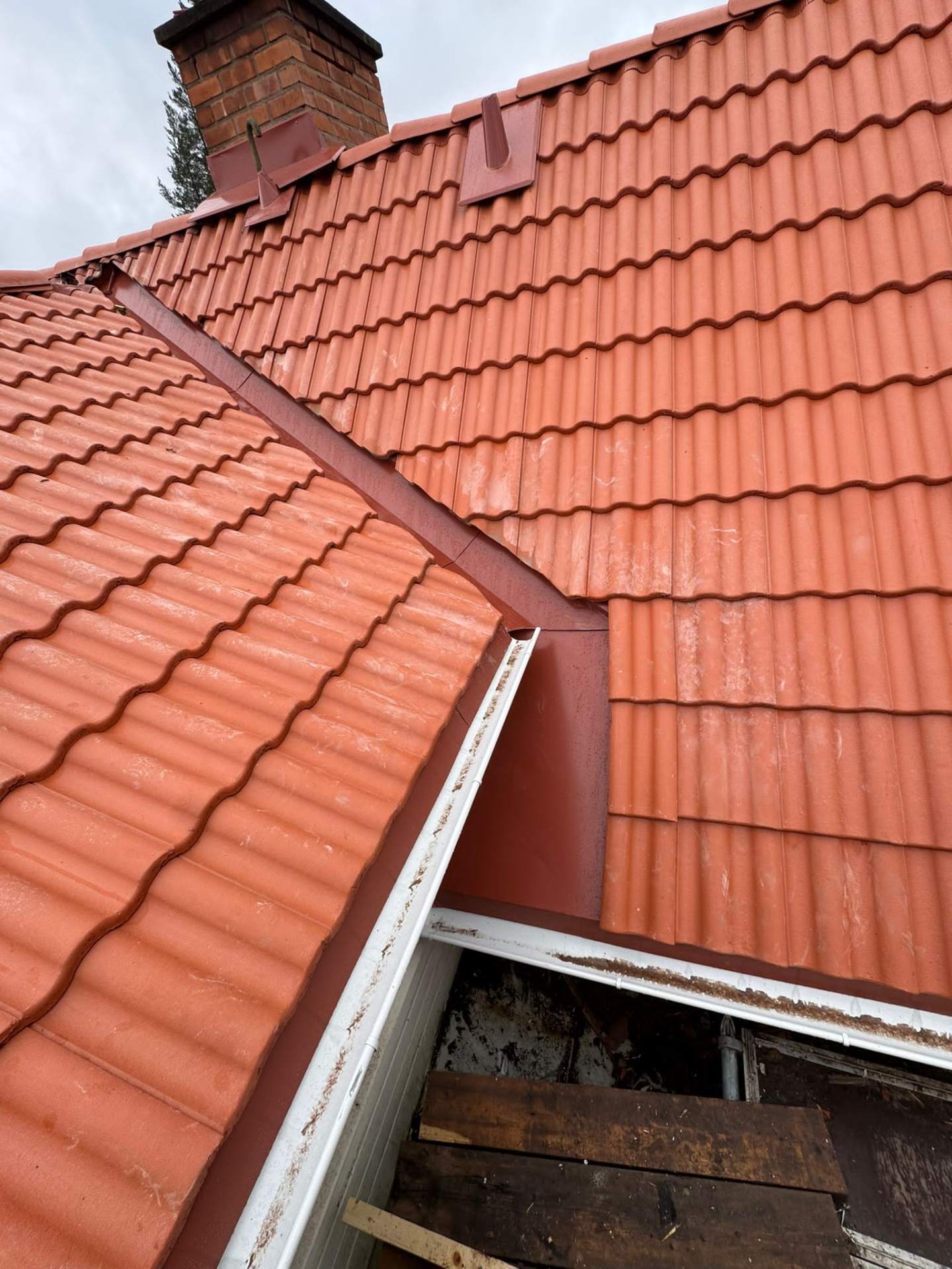 Närbild på nytt tegelprofilerat tak med ny vinkelränna