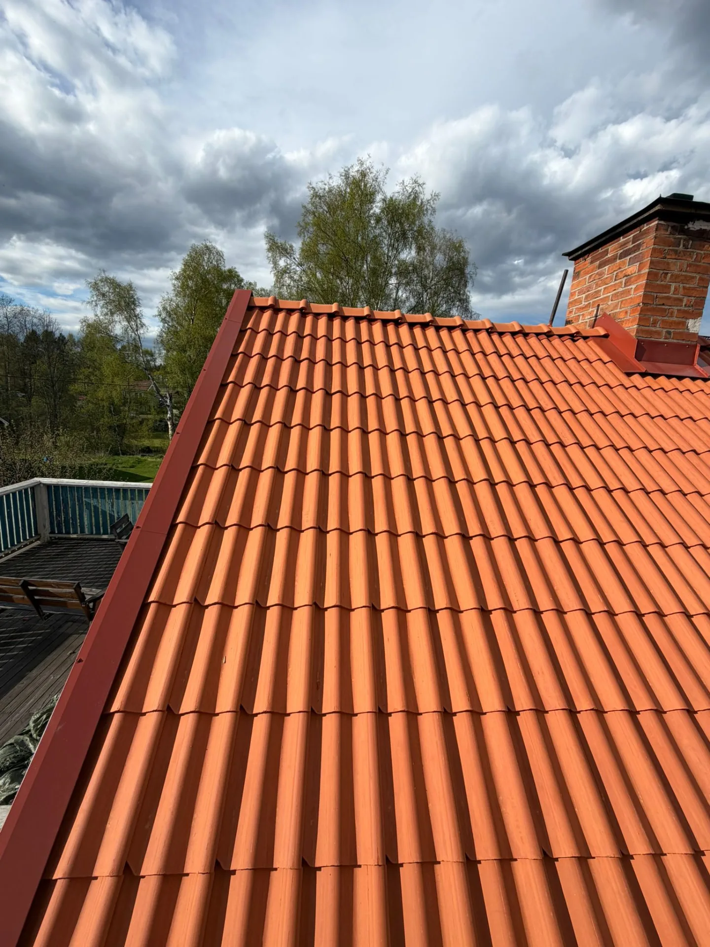 Nytt tegelröd plåttak med skorsten efter takbyte i Dalarna